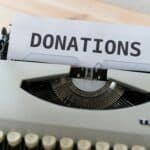 a typewriter with the the word "donations" on its page emphasizing the role of nonprofit newsroom fundraising.