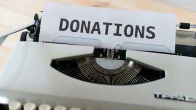 a typewriter with the the word "donations" on its page emphasizing the role of nonprofit newsroom fundraising.