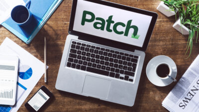 Patch newsroom editors access Dataminr on laptop to monitor real-time breaking news alerts across multiple communities